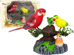 Syngende bevægelige papegøjer på et farverigt træ