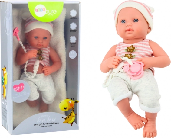 Babydukke i hvid‑rosa outfit med sut og hue