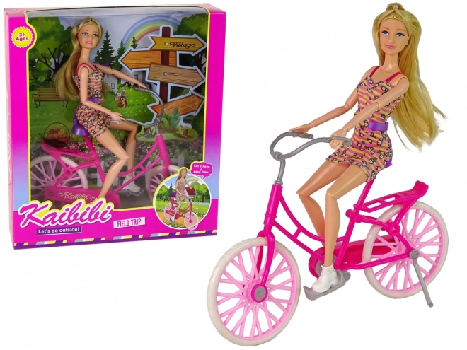 Dukke på lyserød cykel