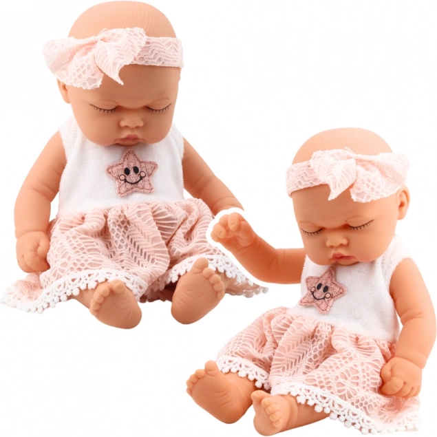 Dukke sovende baby i lyserød kjole med blonder og stjerne-hårbånd