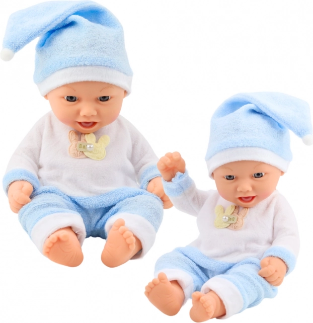 Babydukke i blåt pyjamas med hue med kvast