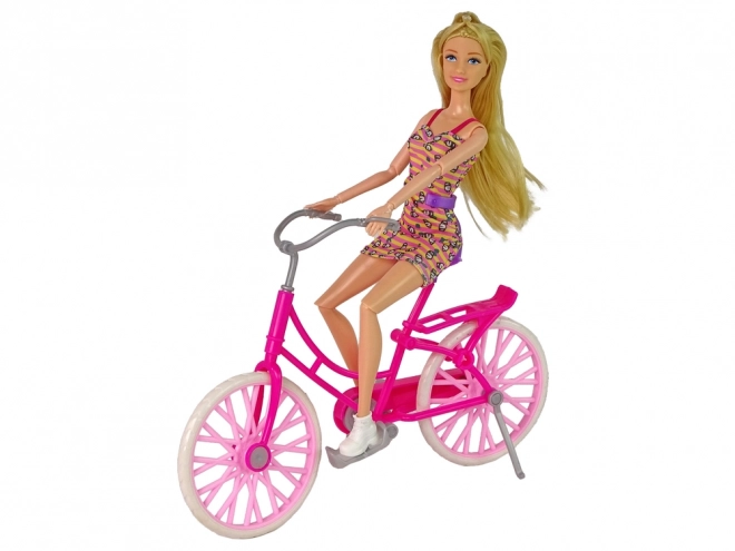 Dukke på lyserød cykel